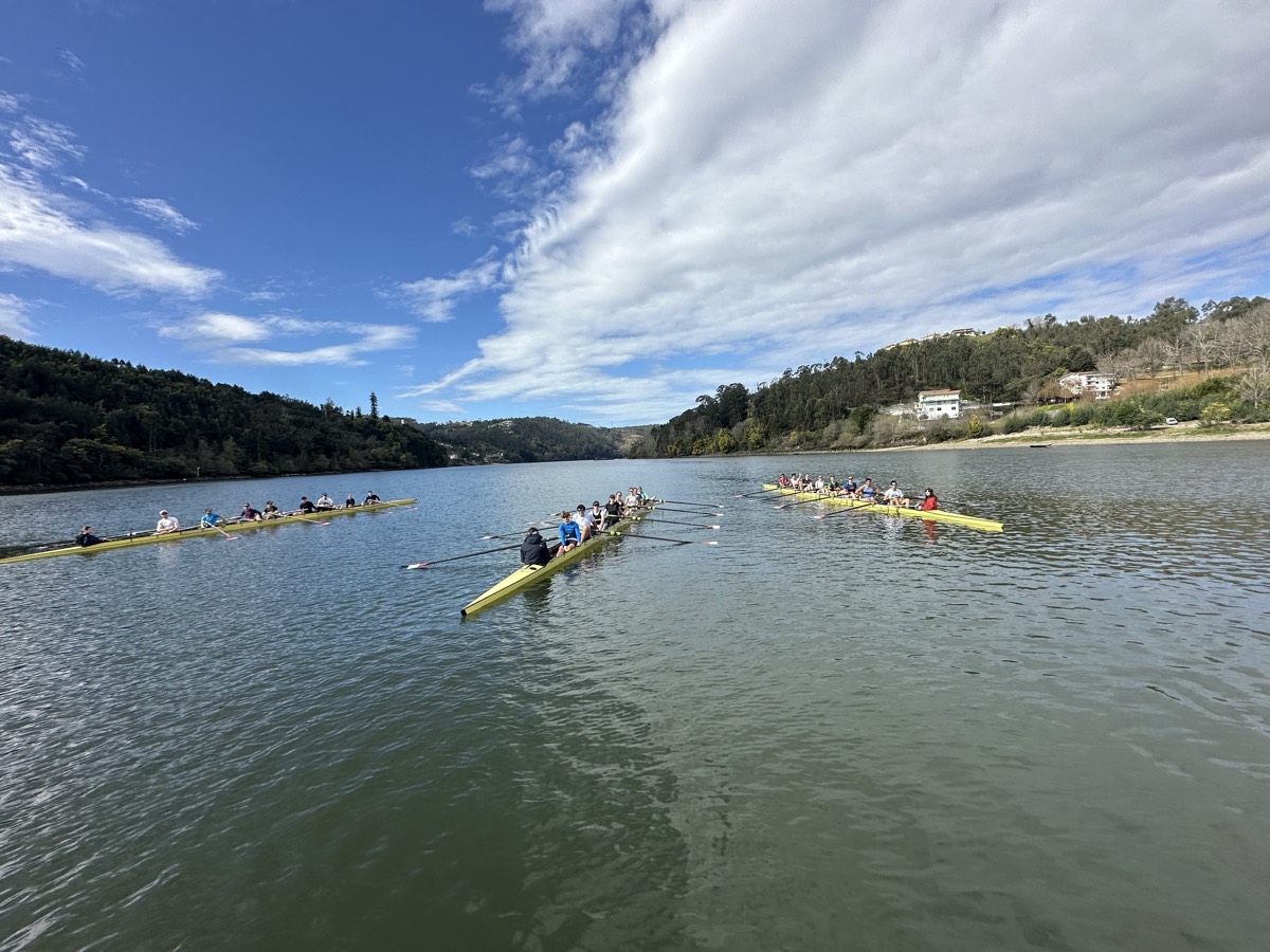 Three crews spread across a wide river under a big sky